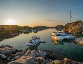 Boats and sailboat moored up in the sunset in Norway